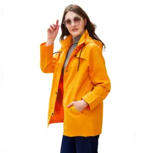 Frau in oranger Jacke mit Kapuze und Taschen
