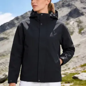 Frau in schwarzer Jacke mit Kapuze beim Wandern in den Bergen