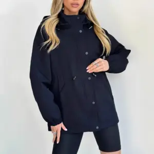 Frau in marineblauem Parka mit Kapuze, Kordelzug an der Taille und Druckknöpfen