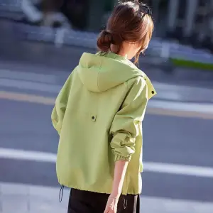 Kurze Jacke in Grün mit Kapuze und Stehkragen, Frau mit Sonnenbrille im Haar von vorn