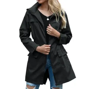 Frau in schwarzem tailliertem Parka mit Kapuze und Taschen auf einer Straße