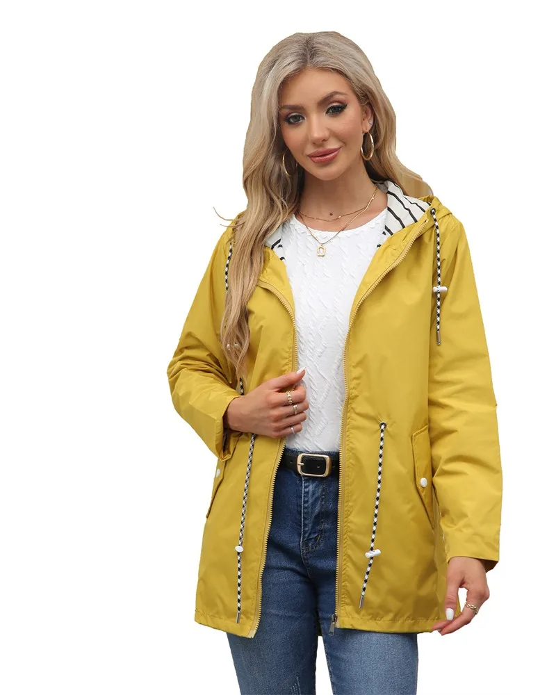 Frau in gelber Regenjacke mit Kapuze und Kordelzug