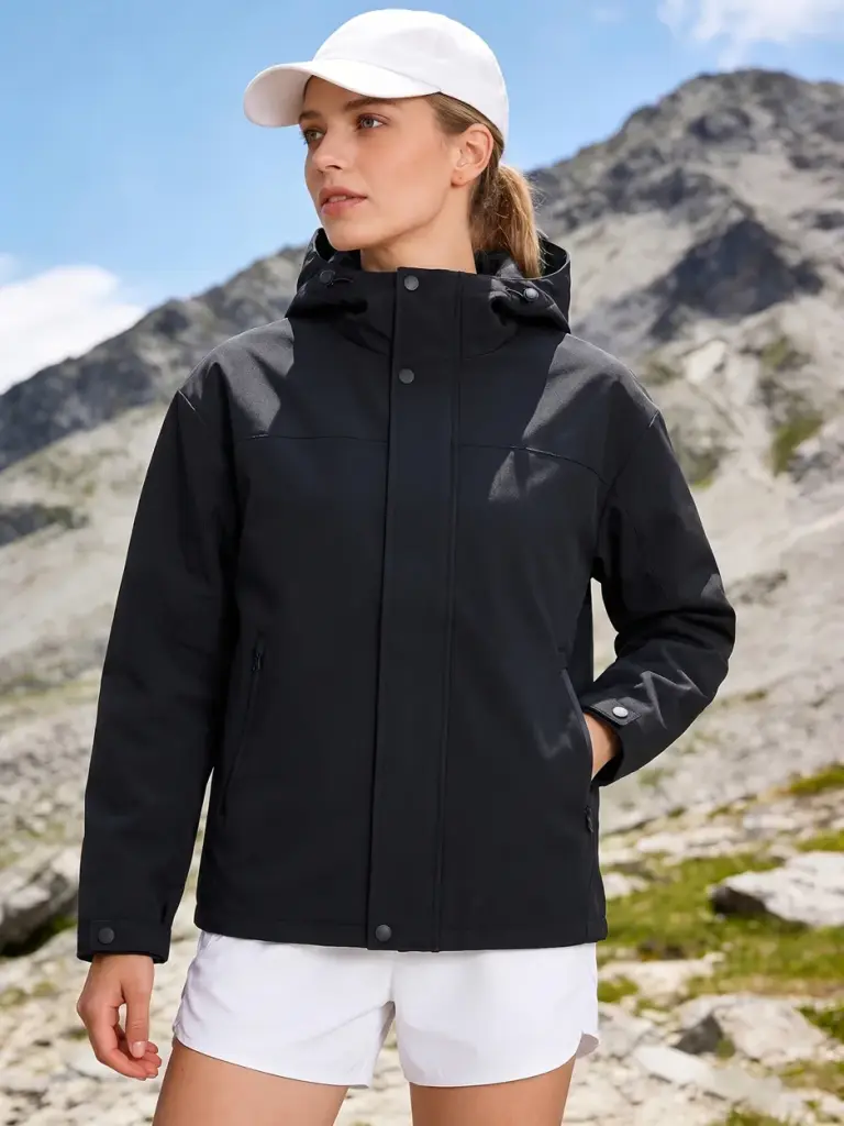 Frau in einer schwarzen Regenjacke vor einer Berglandschaft